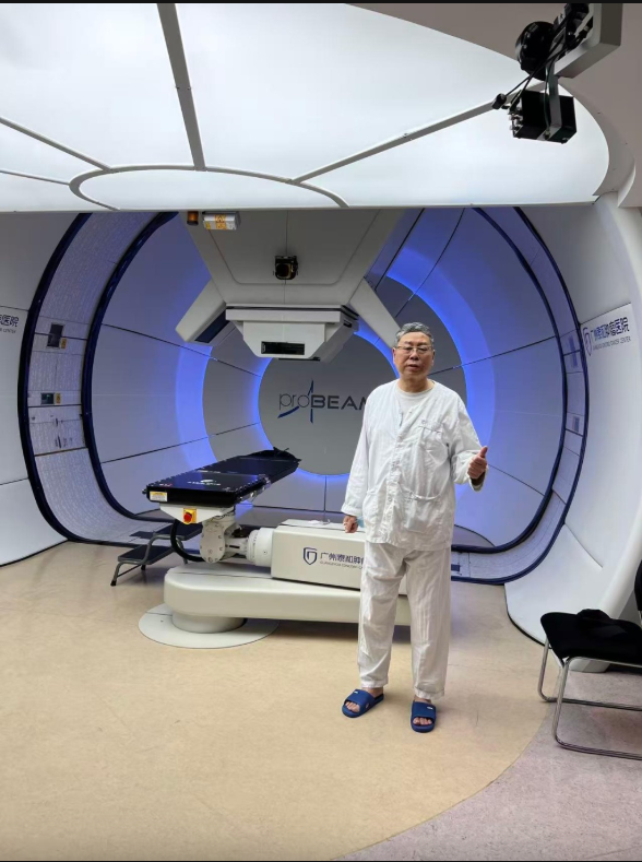 Mr. Lu standing at the ProBeam proton therapy machine at GCCC